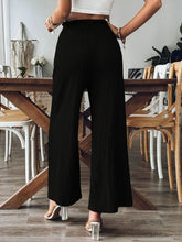 Back view of black Velonni™ trousers highlighting wide-leg flow