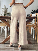 Back view of khaki Velonni™ trousers highlighting wide-leg flow
