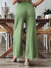 Back view of matcha green Velonni™ trousers highlighting wide-leg flow