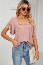 Detail shot of flutter sleeves and embroidered eyelets on Veluretta Mistflair Blouse in peach.