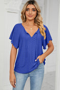 Model wearing the ultra marine Veluretta Mistflair Blouse at a garden brunch with friends.