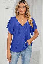 Model wearing the ultra marine Veluretta Mistflair Blouse at a garden brunch with friends.