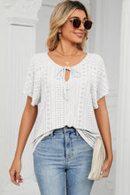 White Veluretta Mistflair Blouse paired with wide-leg pants, sun glasses, jewelry, handbag, and sandals for a late evening walk on the beach.