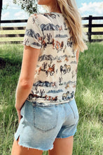 Side profile of the model in the Mustang River graphic mesh tee, styled with layered necklaces and a wide-brim hat.