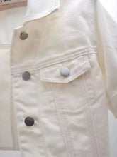 A close up photo of the button detail, pocket, and quality fabric of a white Full Size Cropped Denim Plus Size Jacket.