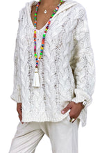 Model wearing the white color Tessyra Cable-Knit Hooded Sweater paired with jewelry and white slacks.