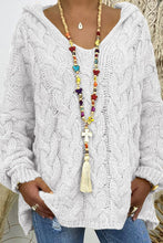Close-up photo of a model wearing the white Tessyra Cable-Knit Hooded Sweater paired with jewelry and blue denim jeans.