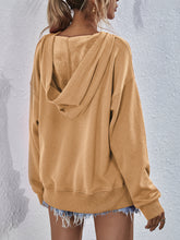 a model showcasing the back of a mustard Zephyra Breeze Dropped Shoulder Hoodie paired with light blue denim shorts.