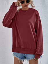 a model wearing a wine color Zephyra Breeze Dropped Shoulder Hoodie paired with tinted glasses, jewelry, and light blue denim shorts.