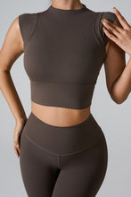 a model posing the front view of the Mocha color Mock Neck Active Tank
