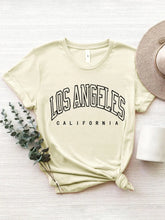 CaliVista Tee in tan paired with straw hat in flat lay, styled for casual summer outfit inspiration.