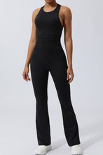 Model in Black AerisCross Vivanta Jumpsuit, front view showcasing crisscross straps and sleek silhouette.