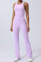 Model in blush pink AerisCross Vivanta Jumpsuit, front view showcasing crisscross straps and sleek silhouette.