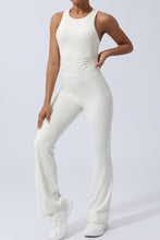 Side view of model stretching arm overhead in white AerisCross Vivanta Jumpsuit.