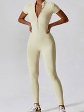 Model doing aerobics in Light Yellow FlowFit Jumpsuit and trainers in gym.