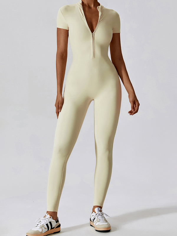 Model in Light Yellow FlowFit Jumpsuit, front view showing half‑zip and slim fit.