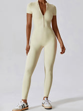 Model in Light Yellow FlowFit Jumpsuit, front view showing half‑zip and slim fit.