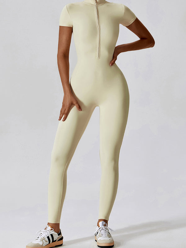 Model lounging reading book in Light Yellow FlowFit Jumpsuit and sneakers.