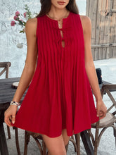 Model styling the scarlet Allurista™ mini dress by a city café table with light breeze.