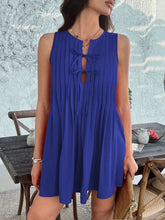 Model in royal blue Allurista™ mini dress posing at a chic rooftop dinner event with shimmering city skyline views.