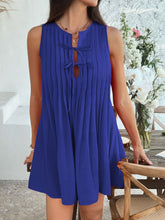 Model in royal blue Allurista™ mini dress at a chic rooftop dinner with city skyline views in the background.
