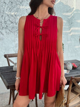  Model in scarlet Allurista™ mini dress twirling at a sunset garden party surrounded by lanterns.