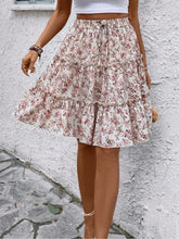 Apricot Florévyn Floral Print Midi Skirt walking view styled with white tube top, highlighting frill tiers and ruffled hem