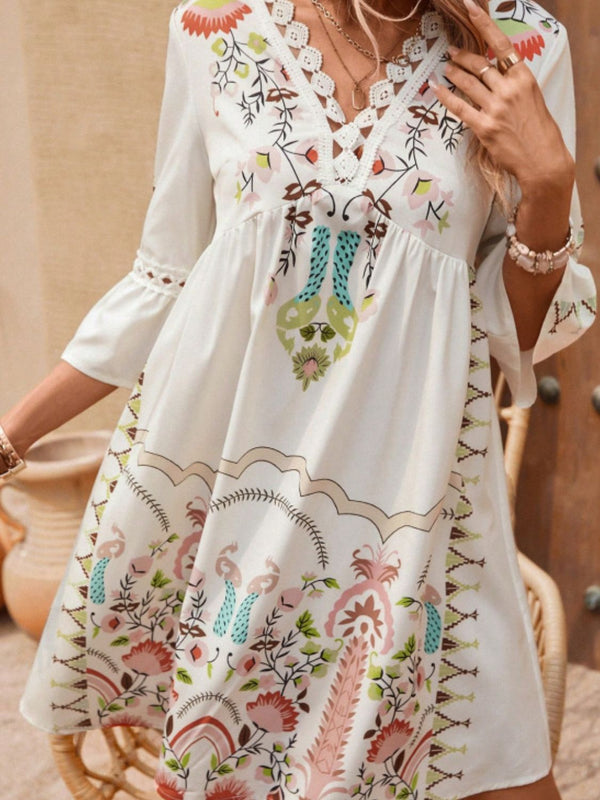 Close-up of Apricot Qelorian Lace Mini Dress highlighting lace trim on V-neckline and floral print details.