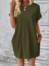Woman heading to a casual art gallery event in Army Green Rahluna Mini Tee Dress styled with layered necklaces and strappy sandals.