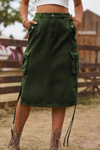 Close-up of Army green Rovelle Cargo Skirt with hands in side pockets