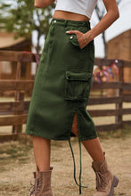 Army green Rovelle Cargo Skirt side view showing button pocket detail with white top and boots