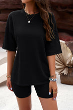 A model wearing the Black Aurelyss Eyelet Round Neck Top and Shorts Set paired with jewelry near ocean cove.