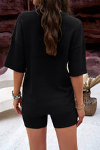 Model back view of a black color Aurelyss Eyelet Round Neck Top and Shorts Set paired with jewelry at a Spa