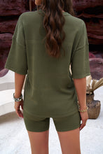 A model showcasing the back of a Matcha Green color Aurelyss Eyelet Round Neck Top and Shorts Set paired with jewelry at a Spa