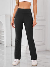 Model wearing AuriCore Flexion Black Pocket Pants, front view showcasing high waist and side pockets.