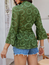 Back view of Luméa™ Blouse in Moss, highlighting the peplum silhouette, accessorized with gold jewelry and heels.