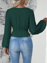 Back view illustrating the dark green Balloonique blouse's fit and design.