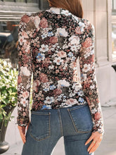 Back view of model in floral black mock neck long sleeve top showing clean lines and fitted silhouette.