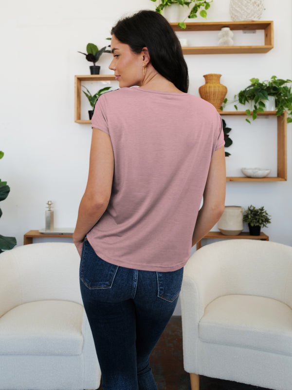 Back view of a dusty pink V-neck short sleeve T-shirt, featuring delicate sheer polkadot mesh detail.