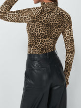 Back view of model in leopard mock neck long sleeve top showing clean lines and fitted silhouette.