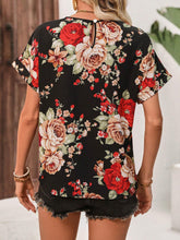Back view of the black rose print contrast trim blouse showing clean, seamless design and relaxed fit, styled with casual jeans for everyday wear.