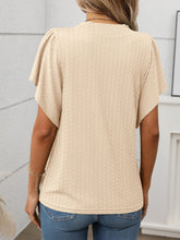 Back view of the tan Round Neck Flutter Sleeve T-Shirt in light blue, showing relaxed fit and flutter sleeve detail, paired with denim shorts.