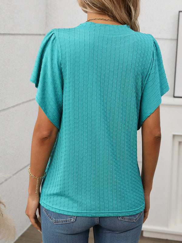 Back view of the Round Neck Flutter Sleeve T-Shirt in  turquoise green showing relaxed fit and flutter sleeve detail, paired with denim shorts.