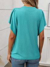 Back view of the Round Neck Flutter Sleeve T-Shirt in  turquoise green showing relaxed fit and flutter sleeve detail, paired with denim shorts.