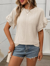 Model wearing Contrast Round Neck Short Sleeve Blouse in Beige, paired with denim jeans, standing against a neutral backdrop.