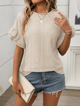 Model enjoying coffee outdoors in Beige Contrast Round Neck Short Sleeve Blouse, paired with light wash jeans and sandals.