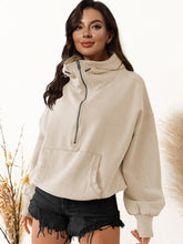 Model wearing the beige color Nuvella Zip-Up Dropped Shoulder Hoodie paired with distressed tan denim shorts.