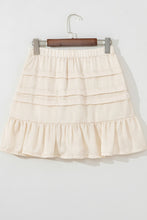 Back view of beige Elunari Ruffled Hem Mini Skirt displayed on hanger