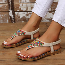 Woman wearing a beige pair of PU Leather Beaded Flat Sandals