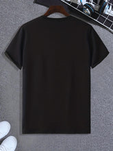 Back view of men’s black Cosmic Voyager astronaut graphic tee styled on hanger with white sneakers